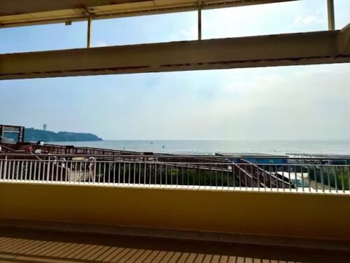 海沿いのデッキから見える砂浜と江ノ島方面の景色