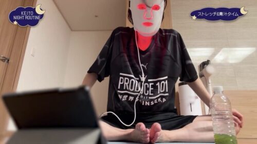 KEITOがLEDマスク型の美顔器をつけながらストレッチしているシーン