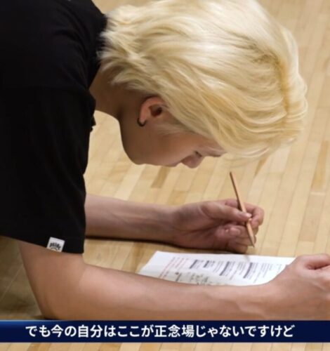 床に置いた紙に書き込むRYUJI