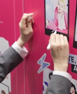 壁に貼られたポスターにサインを書き込むRYUJI